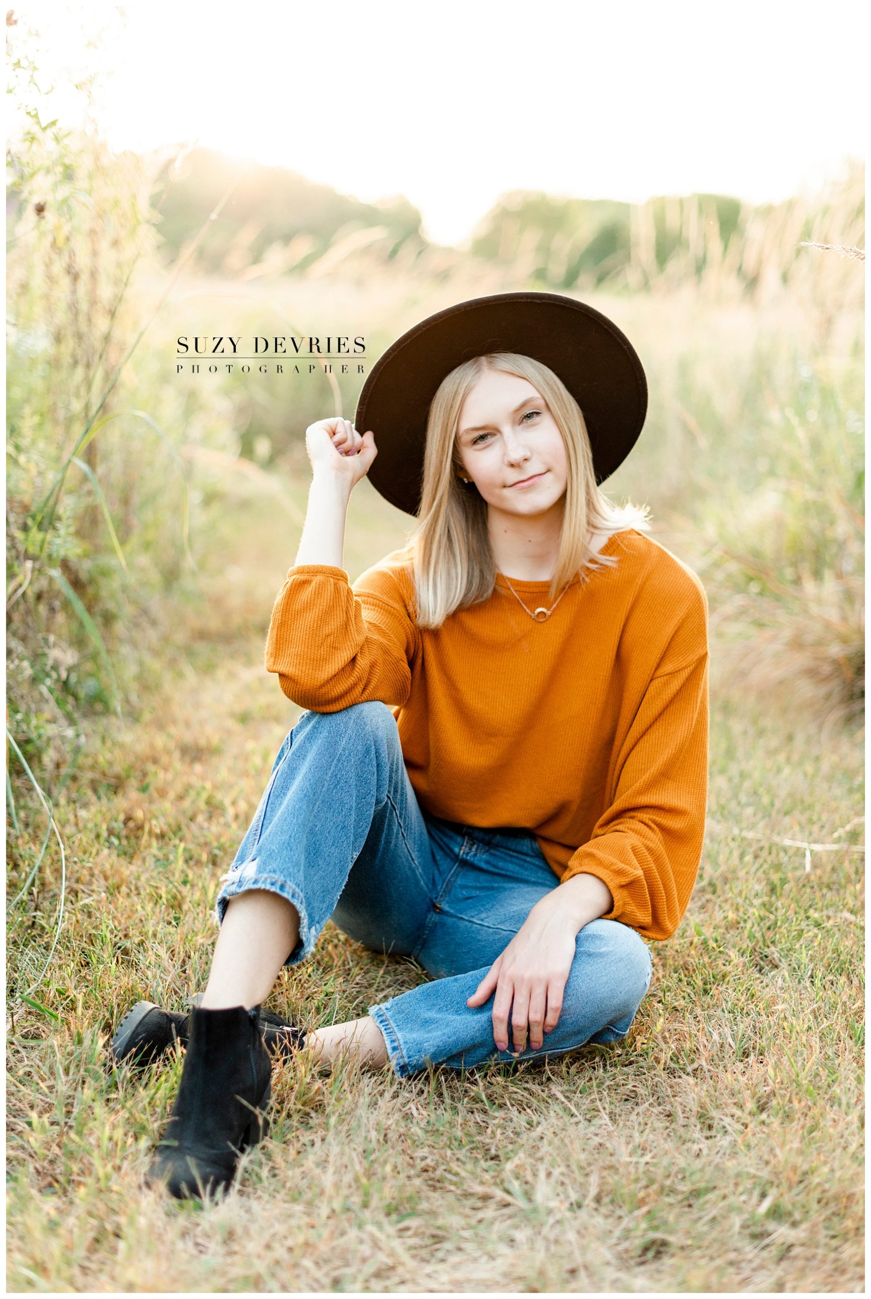 Fall high school girl senior wearing a hat and orange sweater photography